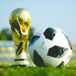 gold-colored trophy and soccerball